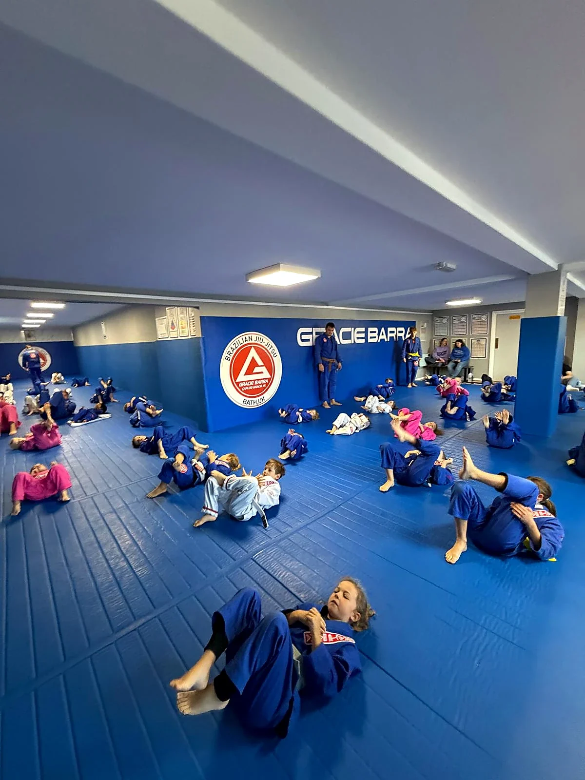 Wide view of the Gracie Barra Bath matted academy during adult training